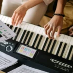 Imagem de duas pessoas estudando harmonia musical no teclado ou algum outro assunto de música