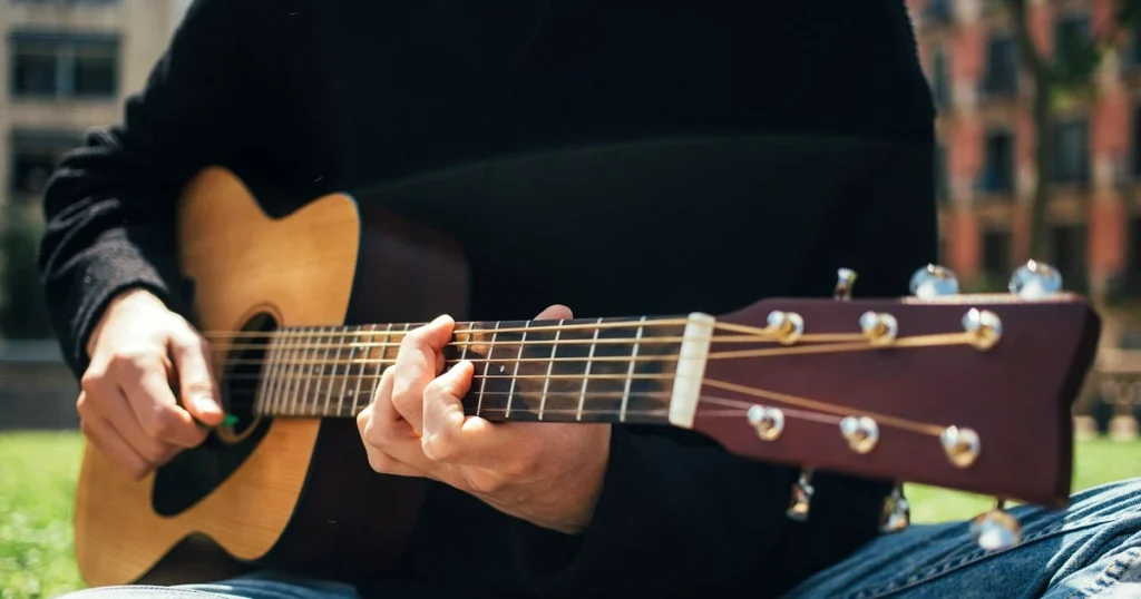 Imagem de uma pessoa fazendo um acorde musical no violão