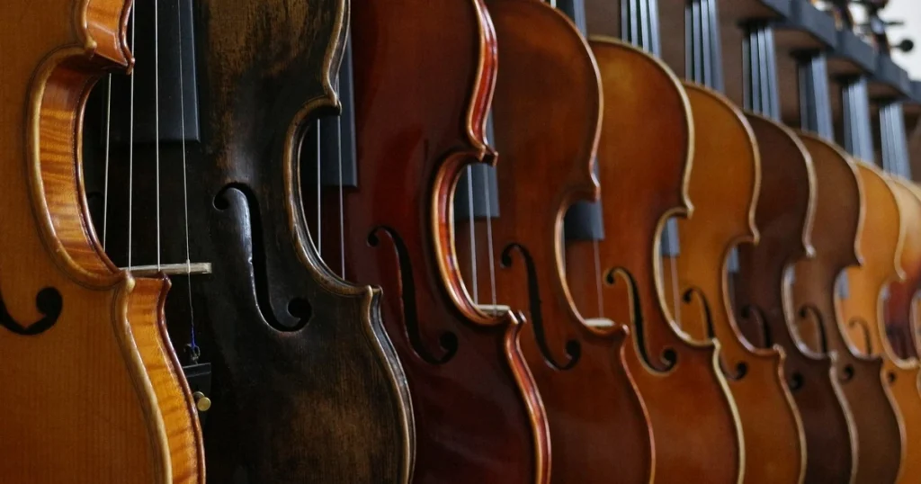 Imagens de vários violinos pendurados na parede