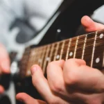 imagem destacada do post escala musical de um músico tocando guitarra