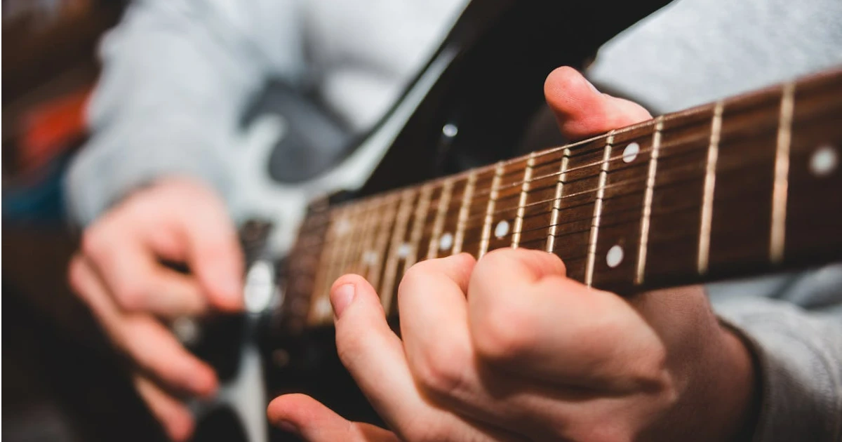 imagem destacada do post escala musical de um músico tocando guitarra